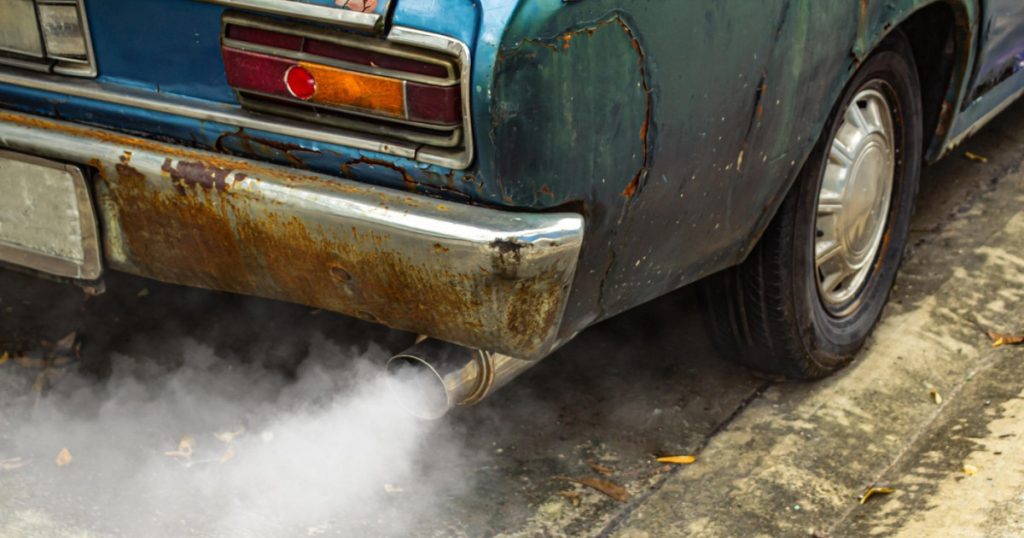 Imagine cu o mașină veche și un semn care indică creșterea impozitului auto în 2026.