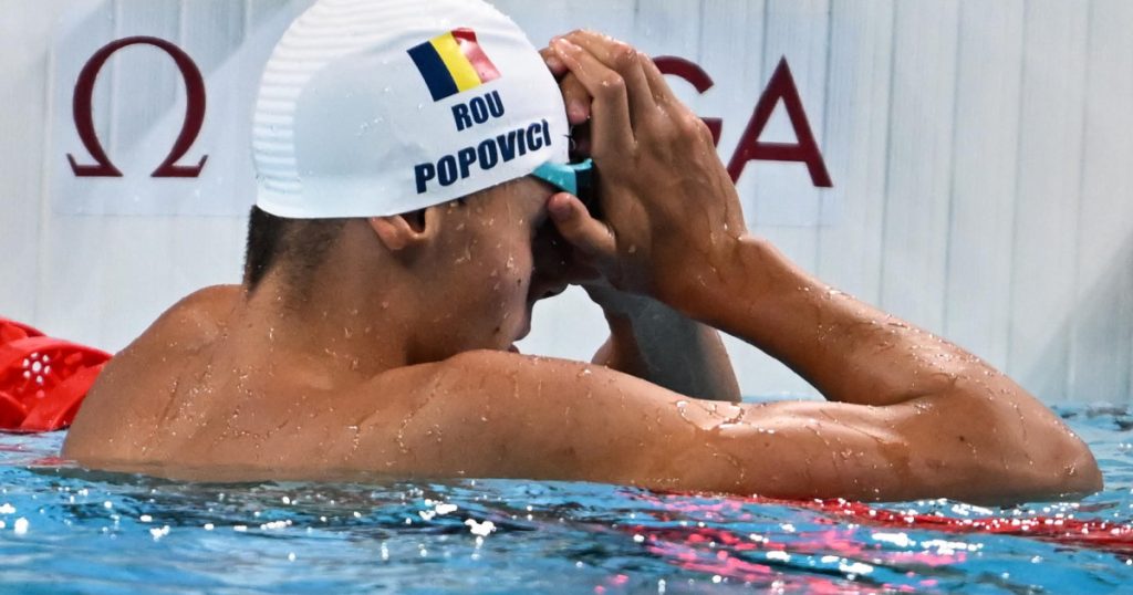 David Popovici, concentrat în apă, pregătindu-se pentru finala de 100m liber, renunțând la proba de 50m liber pentru a-și maximiza șansele la aur.